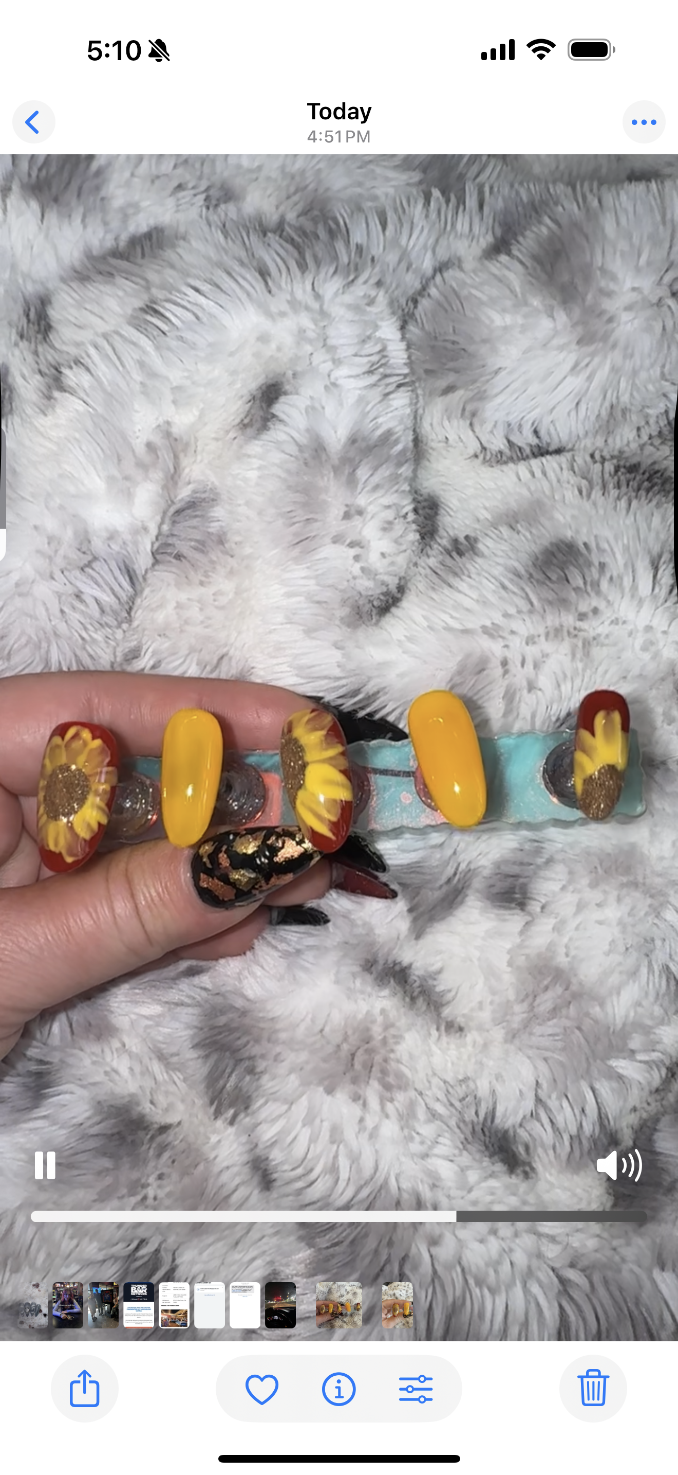 Colorful hair barrette held by a hand on a textured gray surface