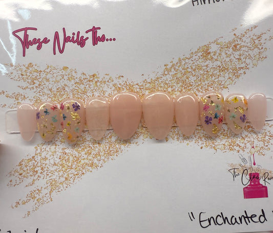 Set of beige press-on nails with floral designs on a white background with gold foil.